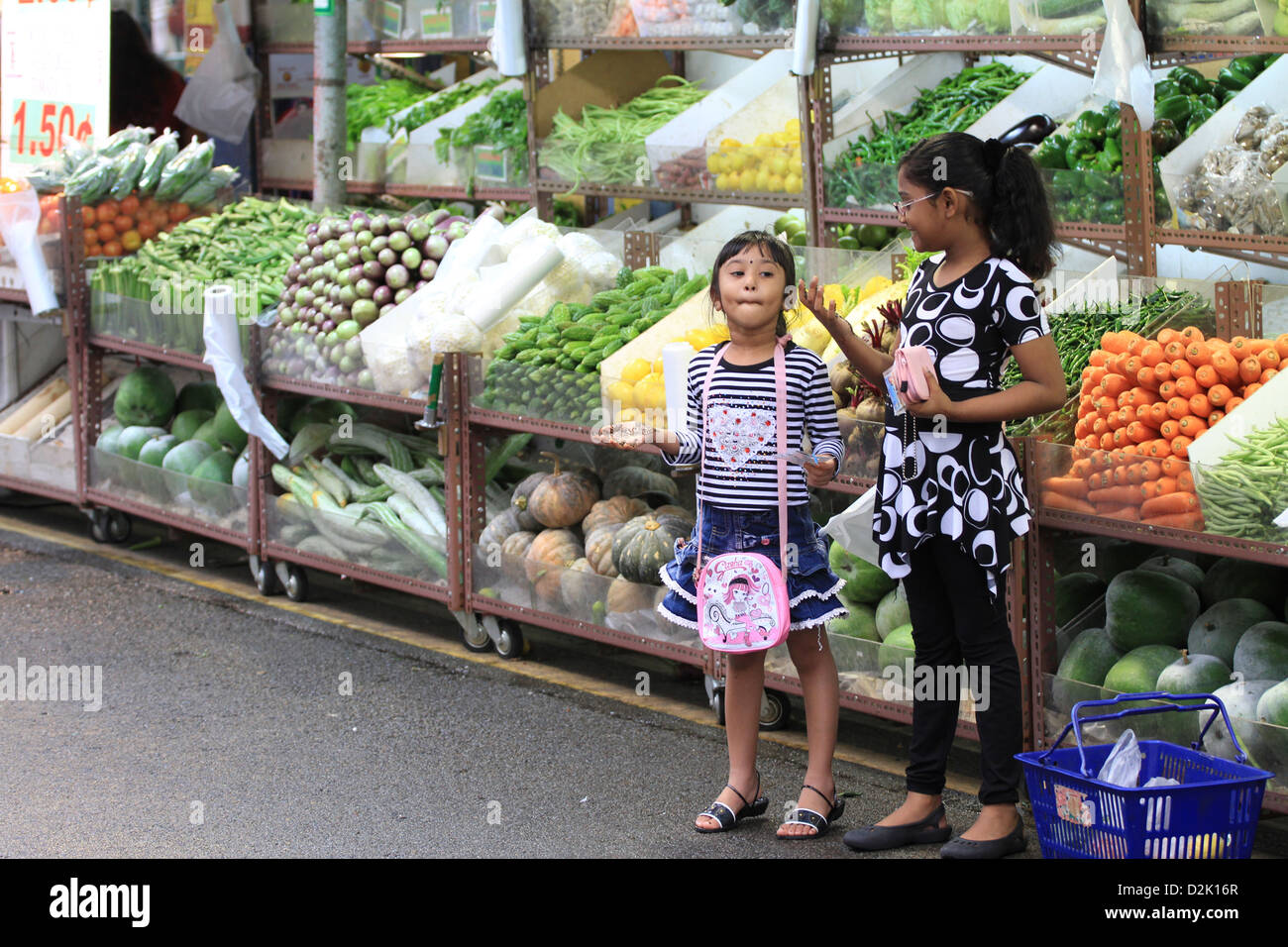 Kids by vegetable street vendor in Little India, Singapore Stock Photo