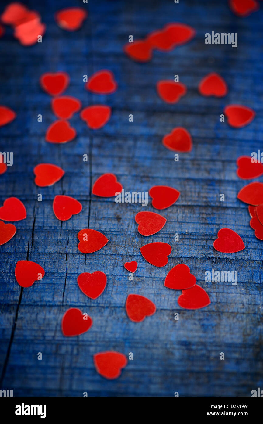 Shiny red love hearts on blue wood background Stock Photo