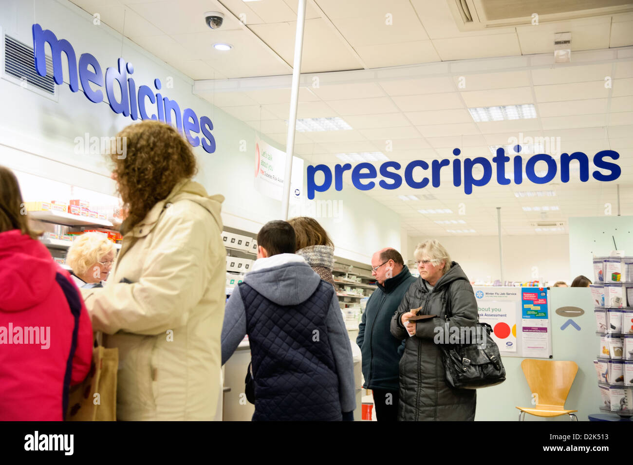 Prescriptions counter inside a Boots shop in Cwmbran, South Wales, UK. People queuing for over the counter medicines. Stock Photo