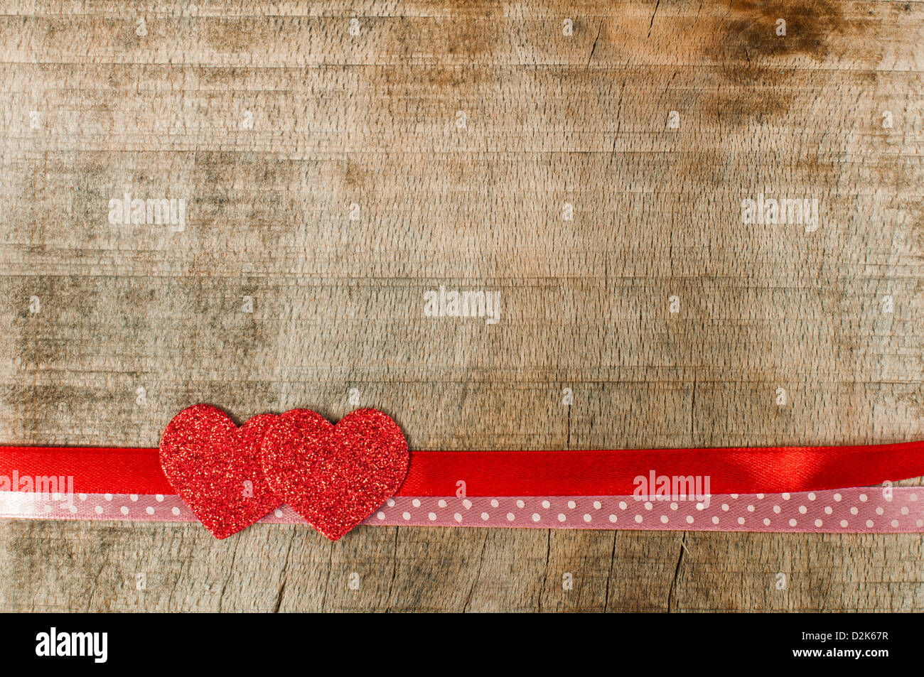 Red ribbon tape and hearts on wooden background Stock Photo - Alamy