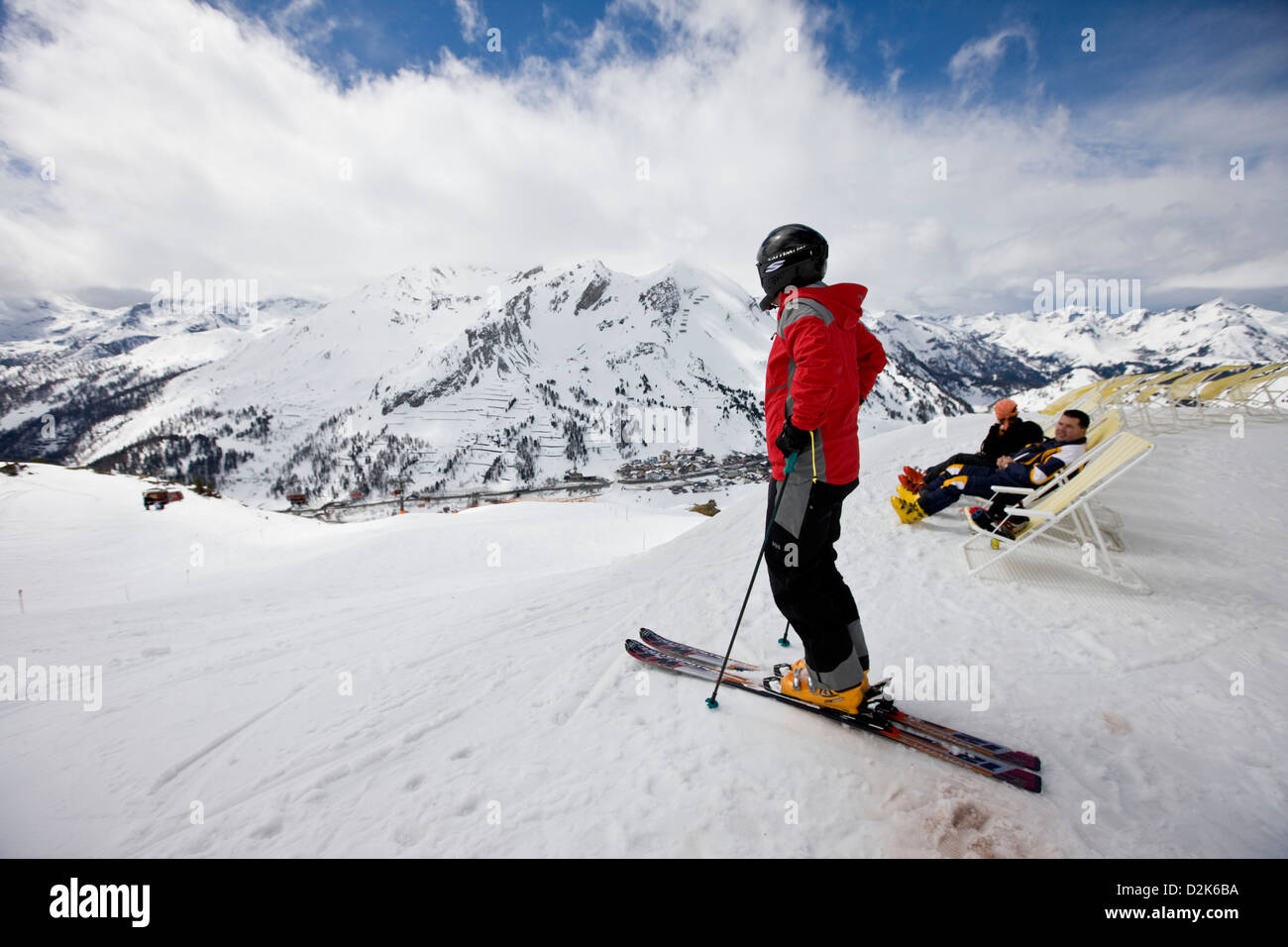 Skier standing looking at view of snowcapped mountaintops, Austria Stock Photo