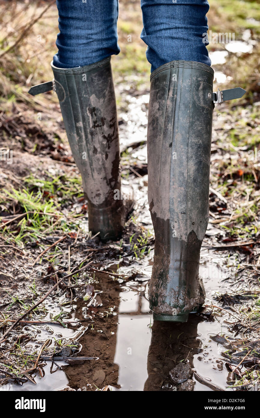Green Hunter (brand) wellies - wellington boots in wet muddy field Stock Photo
