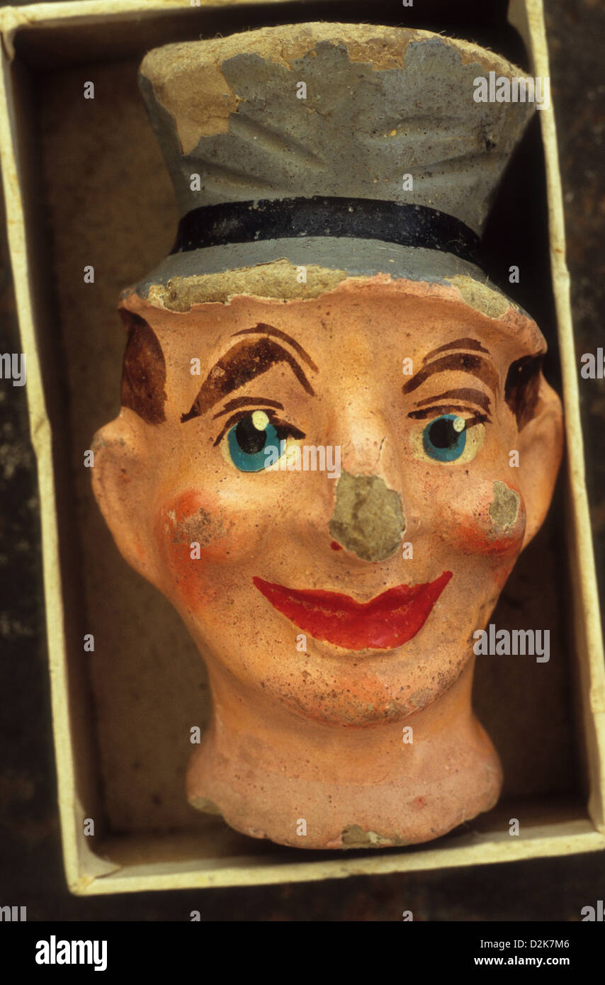 Battered and chipped papier mache male puppet head with top hat lying in cardboard tray Stock Photo