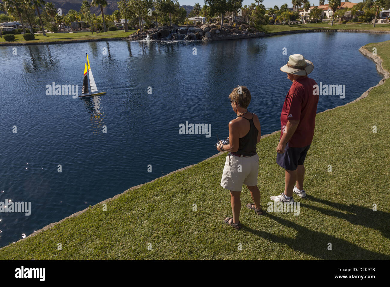 Woman operating a radio controlled Vela One Meter model sailboat Stock Photo