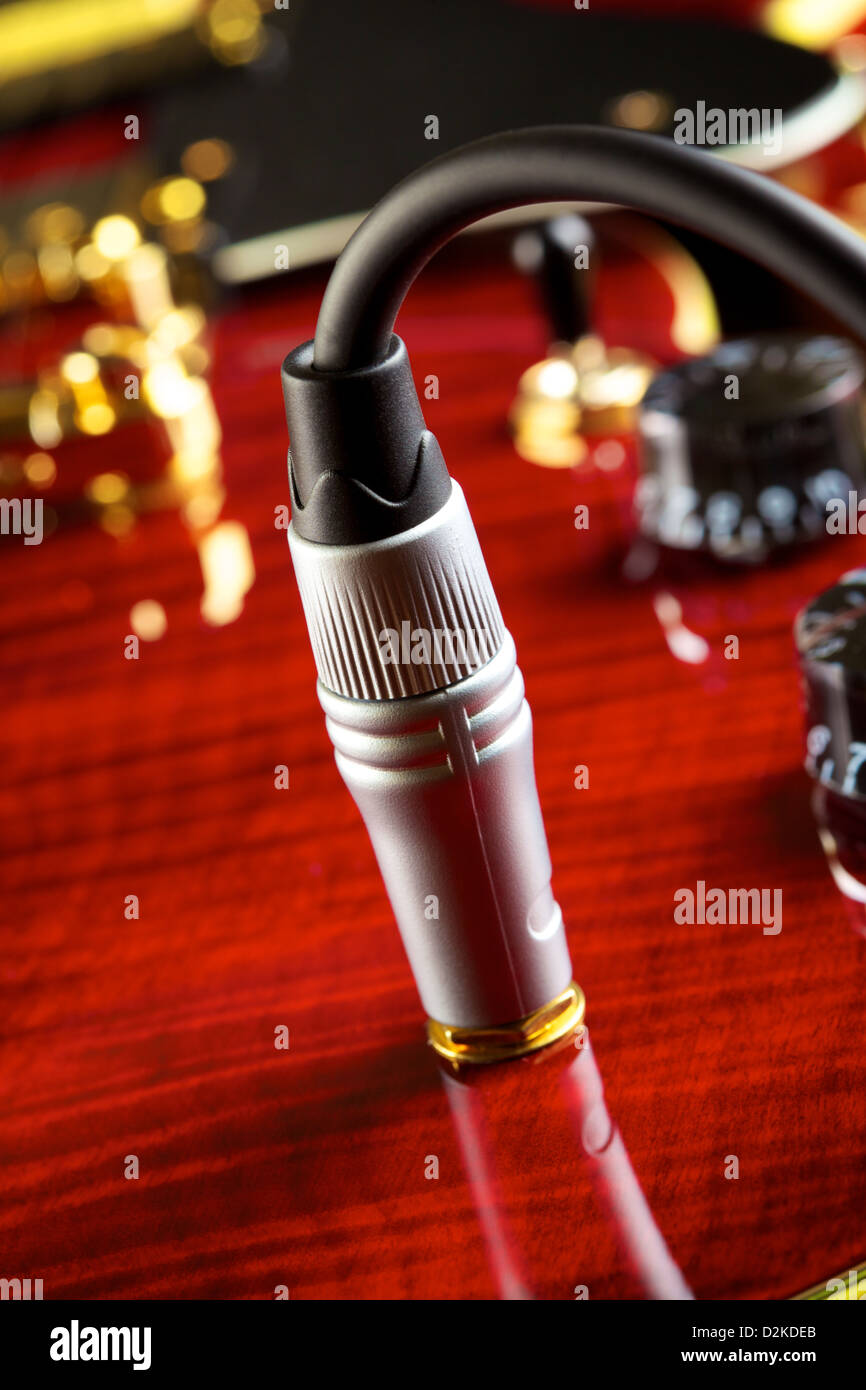 red electric guitar part, cable jack, closeup Stock Photo