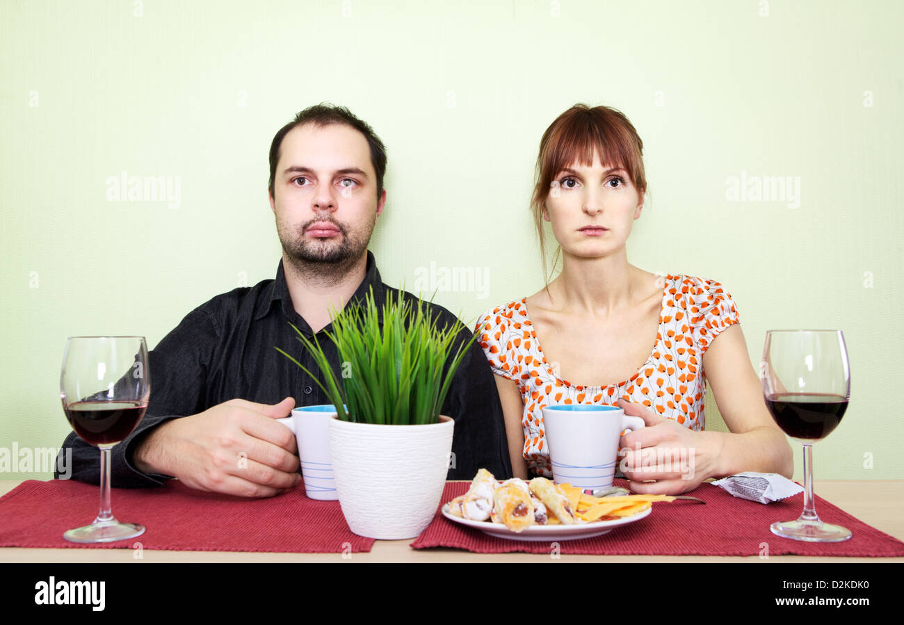 strange couple at the table drink tea and looking nowhere Stock Photo