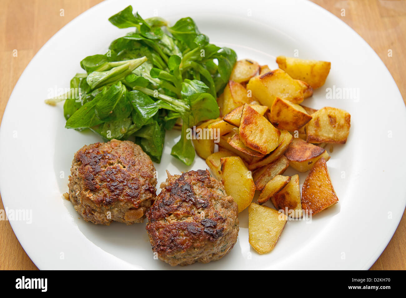 Meatballs with corn salad, bacon, eggs and potatoes Stock Photo