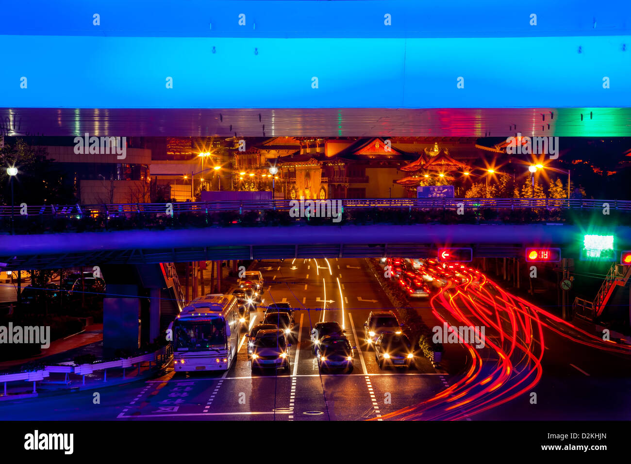 Blue Highway Street Traffic Cars and Light Trails Jingan Temple at Night in Central Shanghai, China. Stock Photo