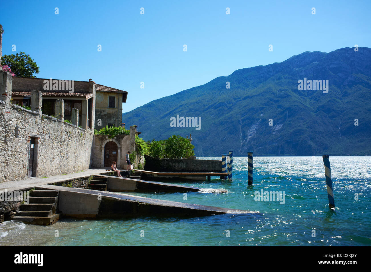 Small beach in Limone town with Monte Baldo in background Stock Photo