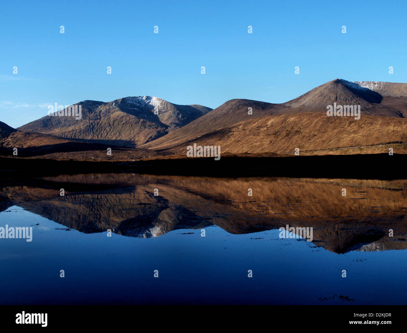 The Red Cuillin mountains of Skye reflected in a Scottish Sea Loch Stock Photo