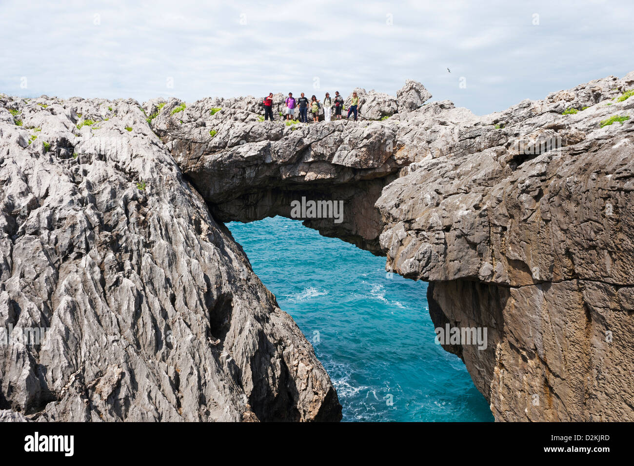 group of people on a natural arch bridge, provinces of Asturias, Spain Stock Photo