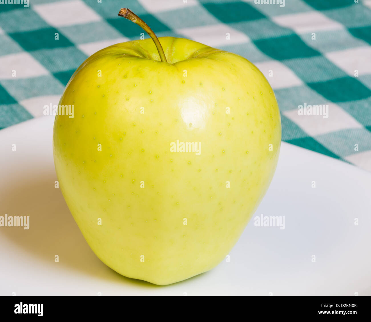 Fresh Golden Delicious apple on a white plate Stock Photo