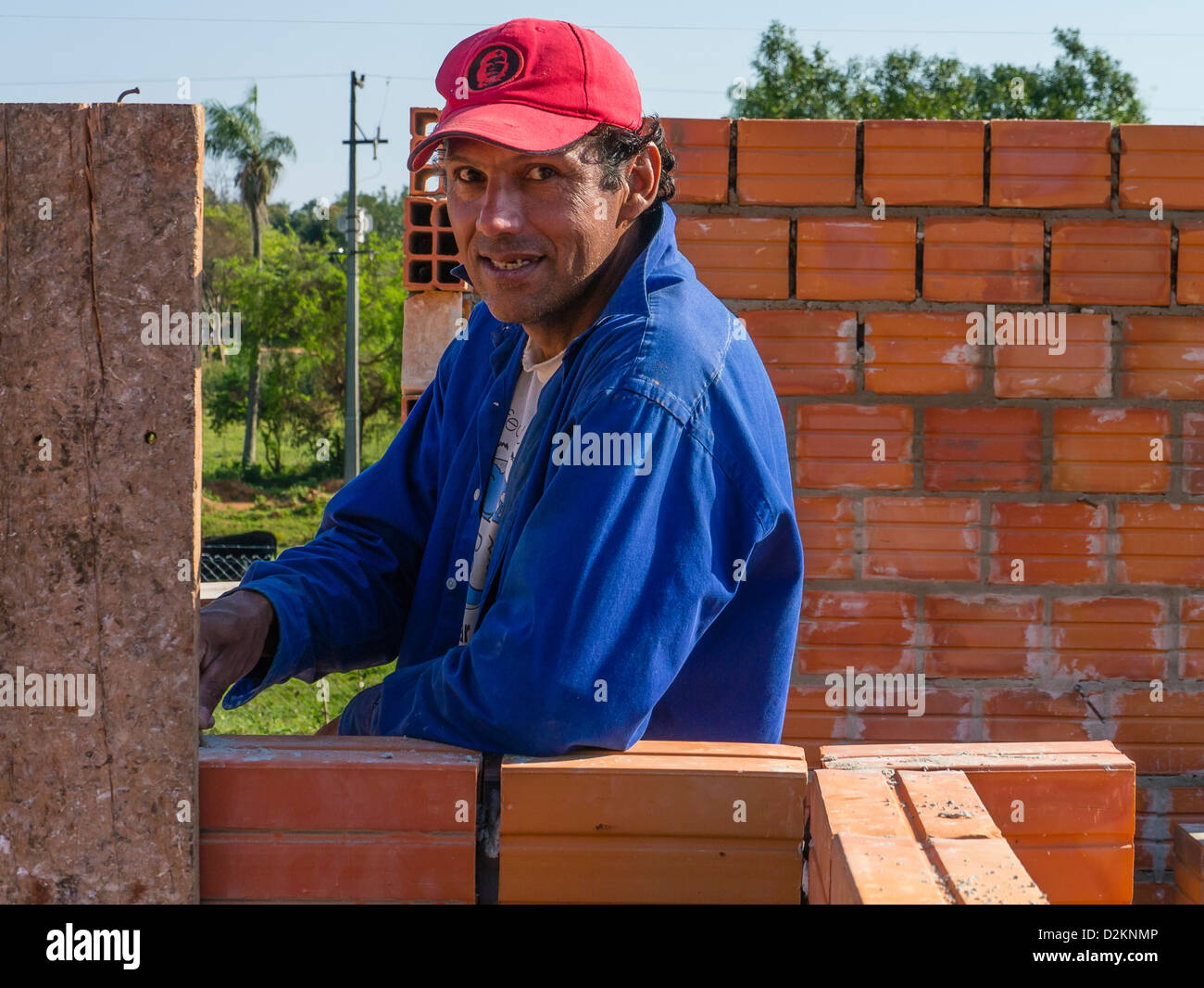 The assistant mason works on a Habitat for Humanity house building site in Luque, Paraguay. Stock Photo