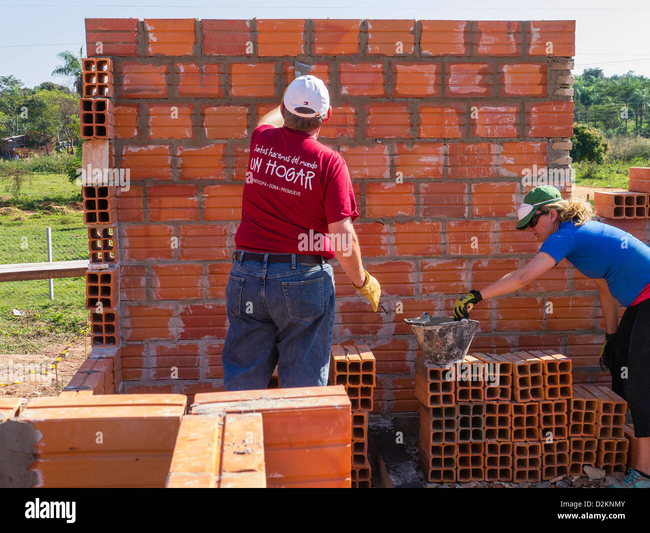 A male & female volunteer from the USA working on the house construction by  on a Habitat for Humanity site in Luque, Paraguay. Stock Photo