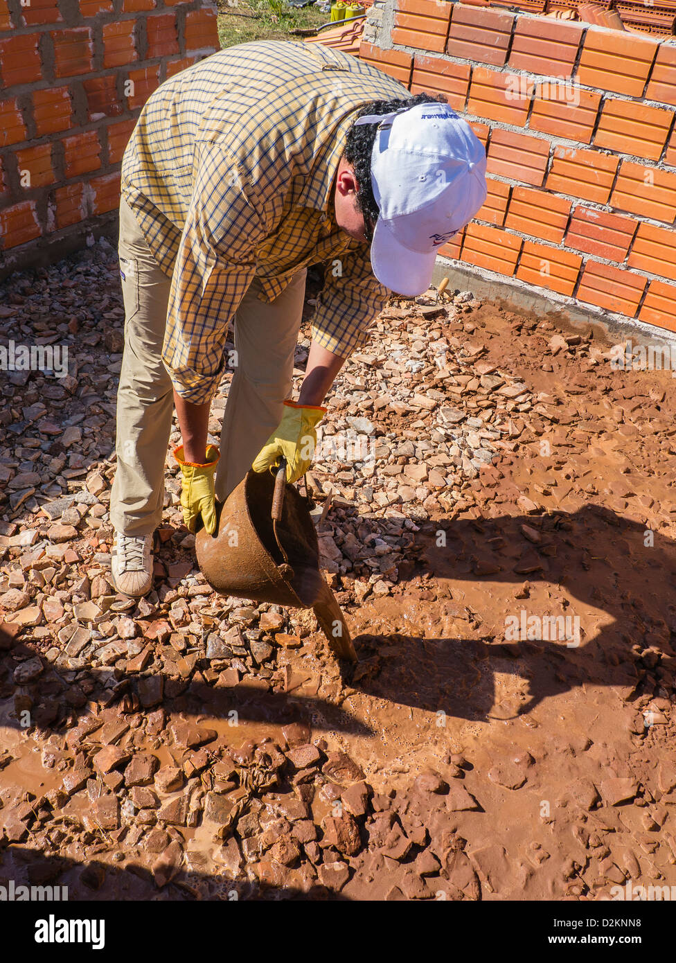A image of a male volunteer working on the house construction by  on a Habitat for Humanity site in Luque, Paraguay. Stock Photo