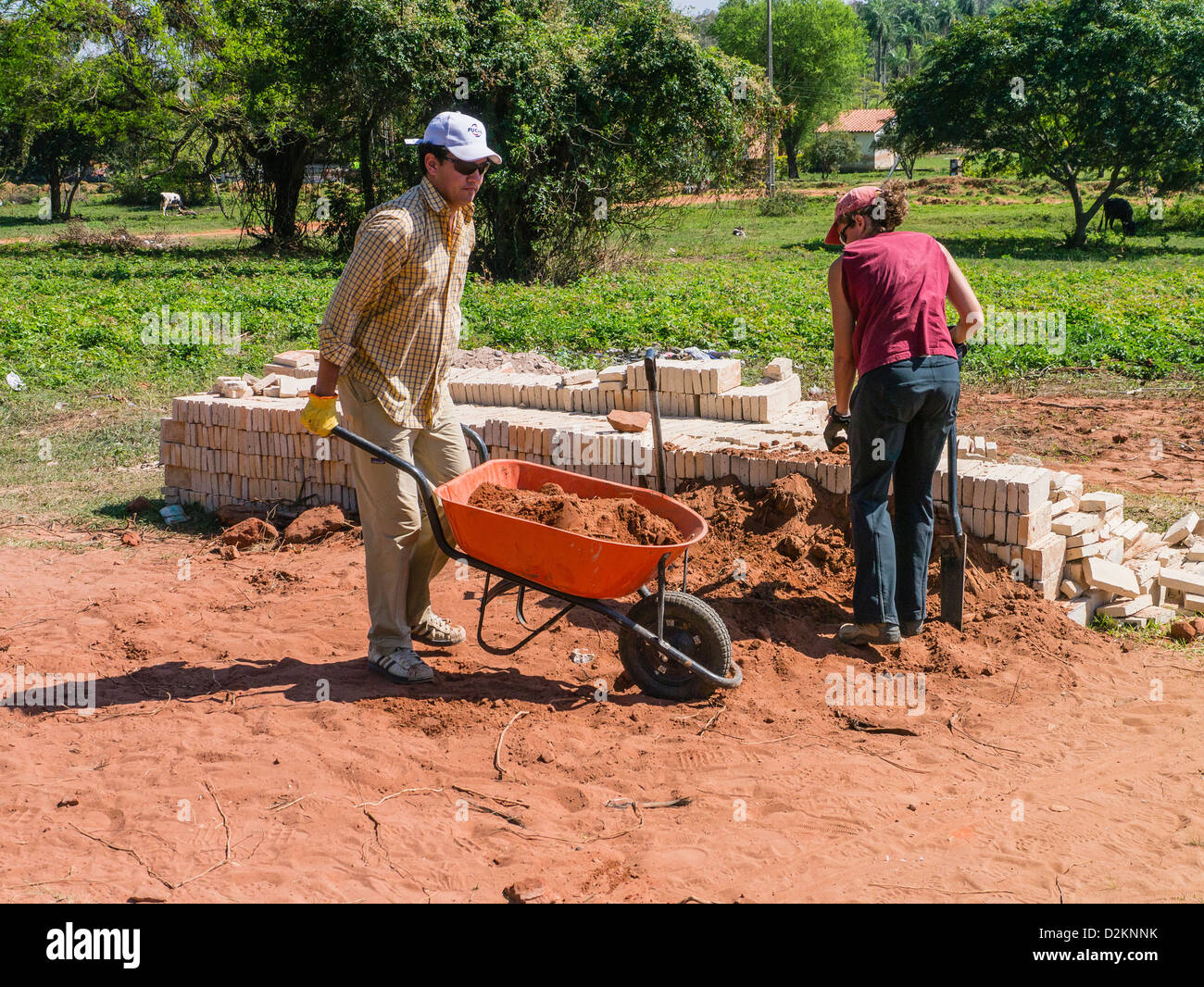 Two international volunteers for Habitat for Humanity work on a house construction site in Luque, Paraguay. Stock Photo