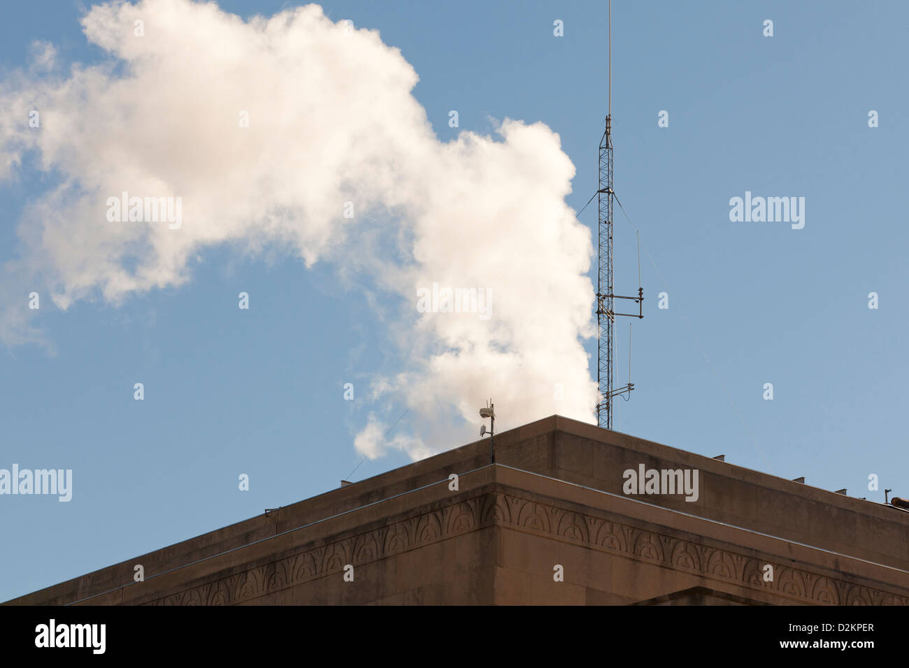 Steam rising from atop a building Stock Photo