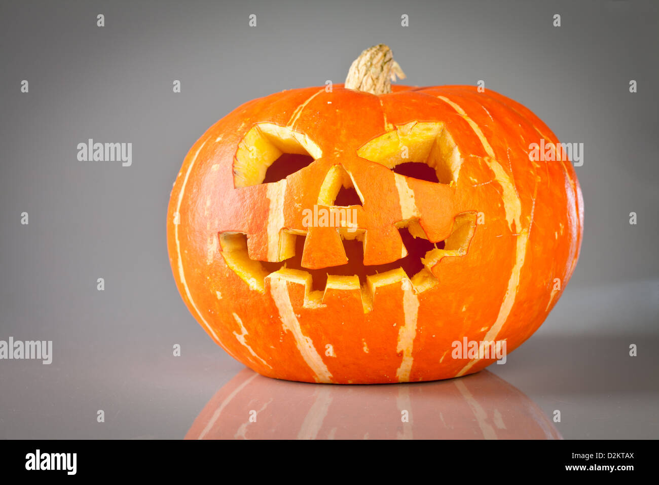 Scary old jack-o-lantern on grey background Stock Photo