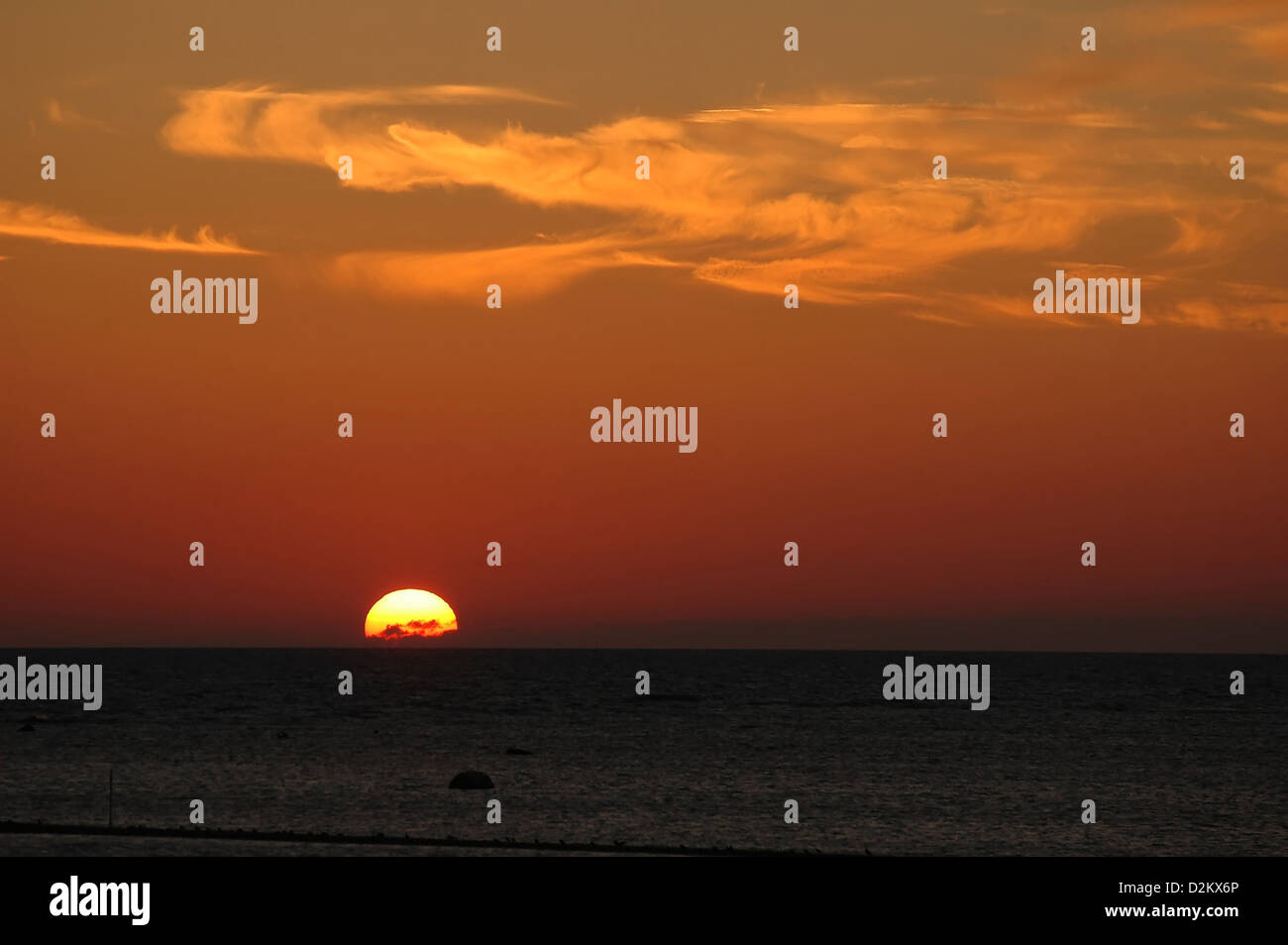sunset at seaside with orange clouds Stock Photo - Alamy