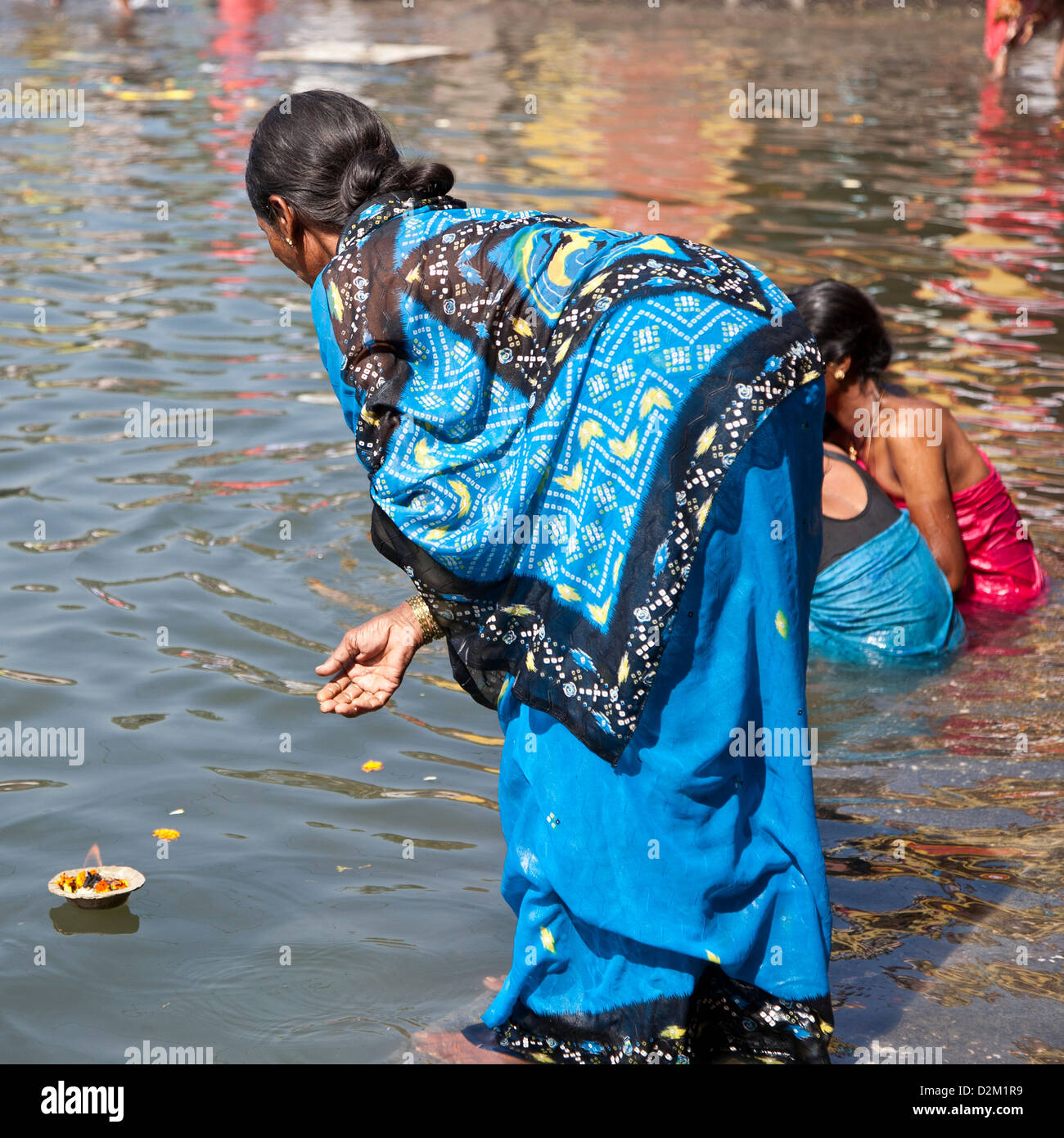 Hindi woman making a ritual offering (floating lamp). Godavari river
