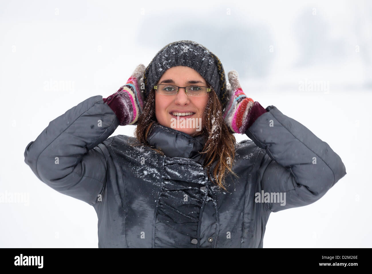 Young happy woman enjoying snow and winter outdoors. Stock Photo