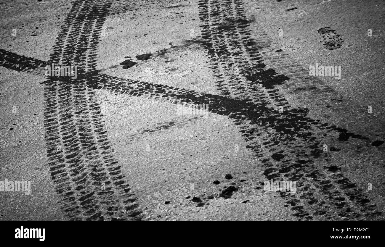 Tire tracks and footstep on the asphalt urban road Stock Photo