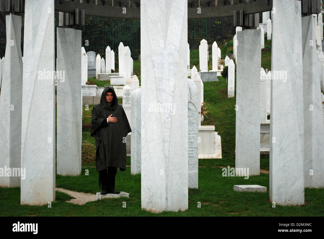 The grave of former Bosnian President Alija Izetbegović guarded by a soldier. The grave was damaged by a bomb attack in 2006. Stock Photo