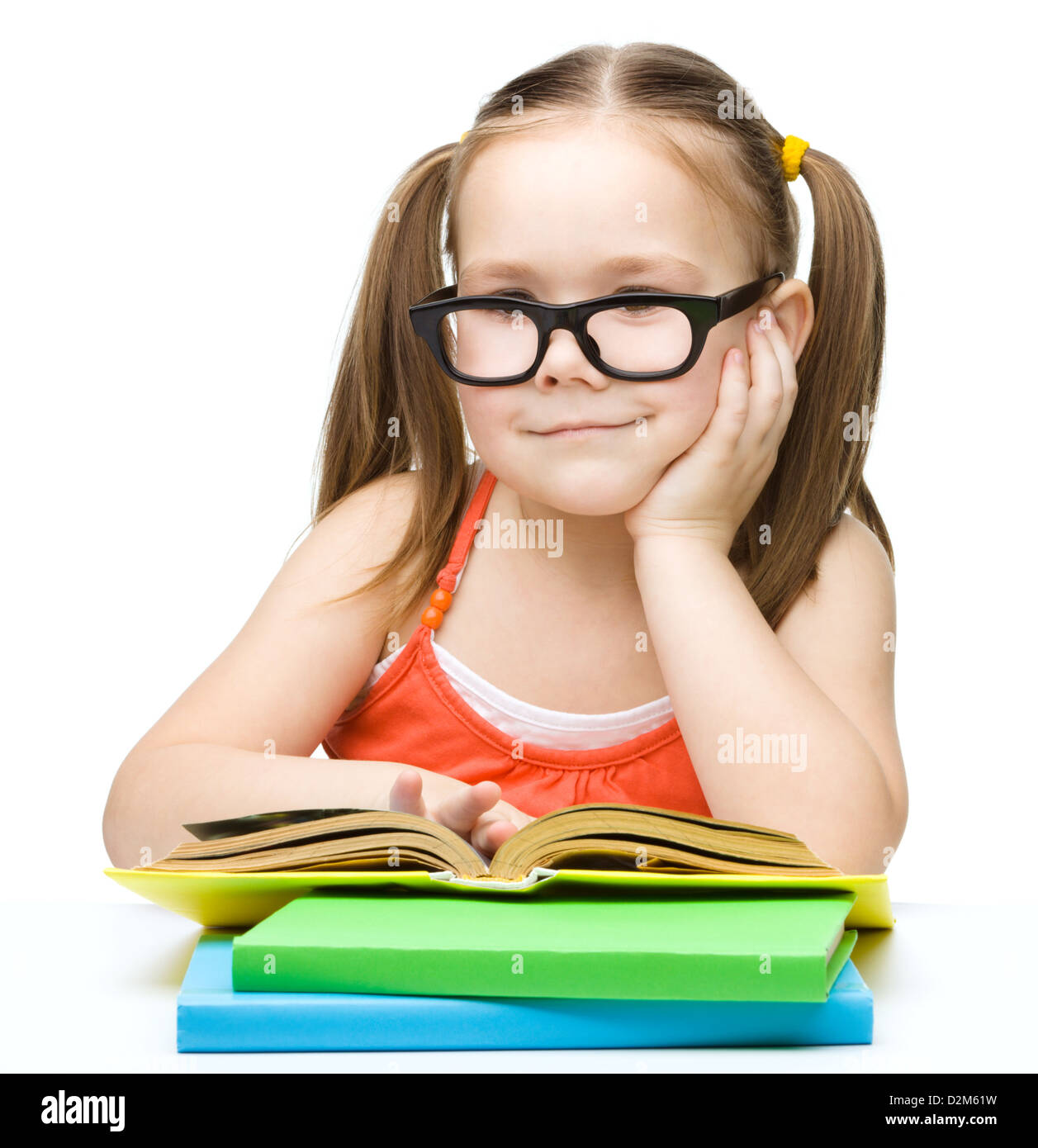 Cute little girl is reading a book while wearing glasses, isolated over ...