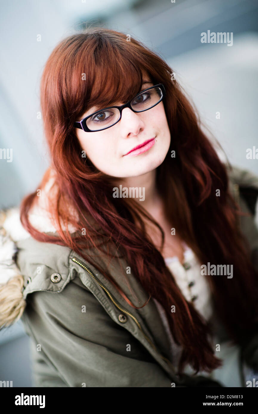 A nineteen year old girl young woman, with long brown hair, wearing glasses, UK Stock Photo