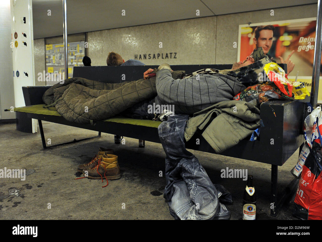 A homeless person rests on a bench in an underground station in Berlin ...