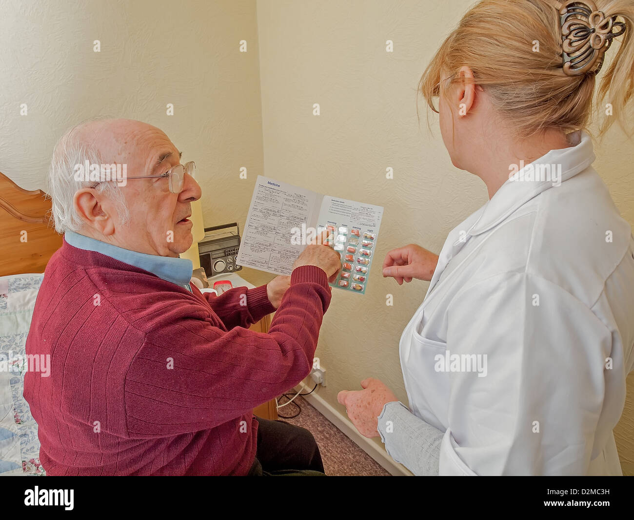 elderly man with carer and blister pack of medications Stock Photo Alamy