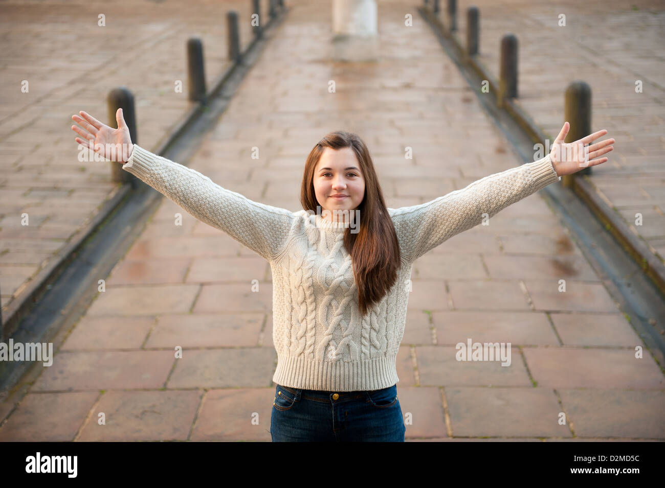 https://c8.alamy.com/comp/D2MD5C/teenage-girl-with-her-arms-stretched-out-and-standing-on-a-walkway-D2MD5C.jpg