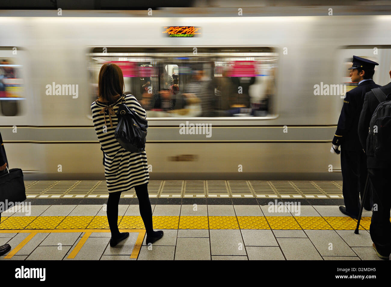 Girl and subway train, with station employee, Tokyo, Japan Stock Photo Alamy