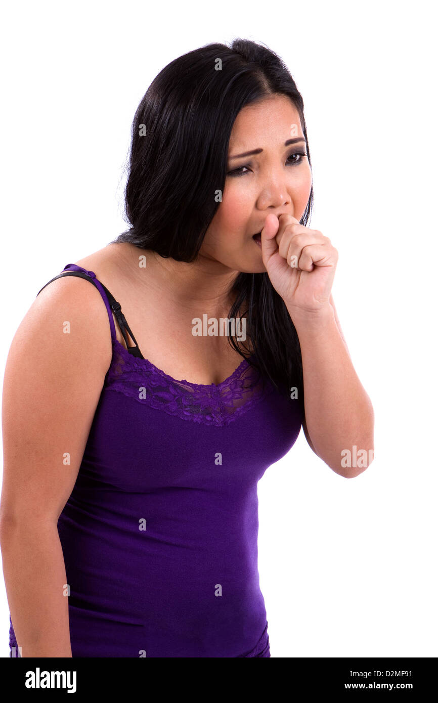 Asian teenager sick with a cold and flu coughs into her fist. Stock Photo