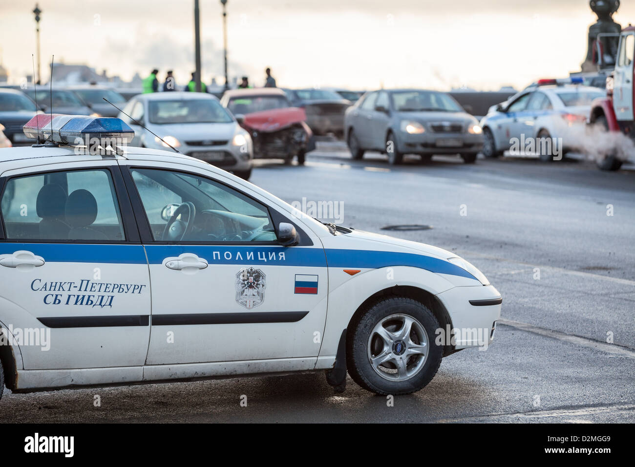 Russian police car is at the accident site with crashed car on background in St. Petersburg, Russia. Frontal impact. Stock Photo