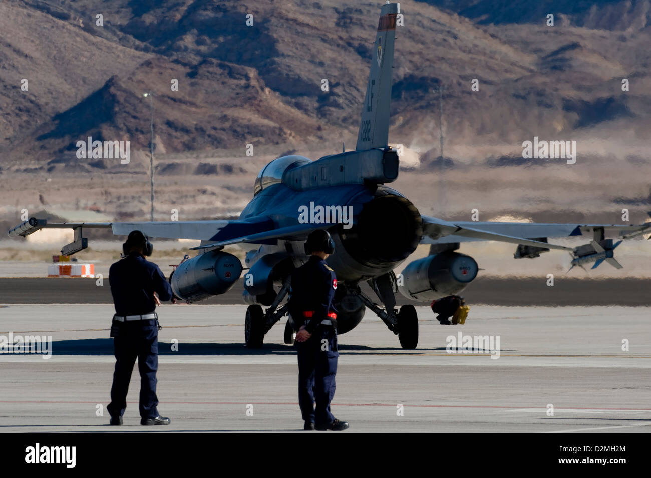 Airmen from the Republic of Singapore Air Force assigned to the 425th Fighter Squadron, Luke Air Force Base, Ariz., watch a Block 52 F-16 Fighting Falcon taxi toward the runway during RED FLAG 13-2 Jan. 21, 2013, at Nellis Air Force Base, Nev. Initially l Stock Photo
