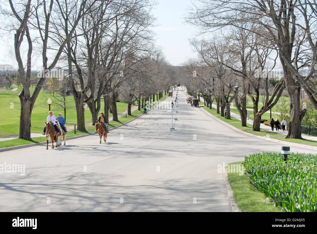 Horses and riders on Grand Avenue toward Grand Hotel, Mackinac Island,  Lake Huron, Michigan, USA Stock Photo