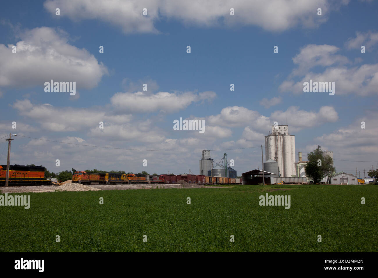 Train stopped at a rural grain mill Stock Photo