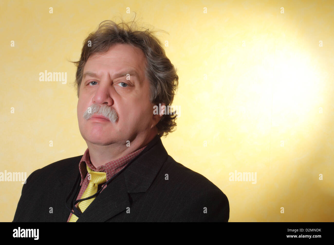 Handsome middle age business man wearing a suit on a yellow background Stock Photo