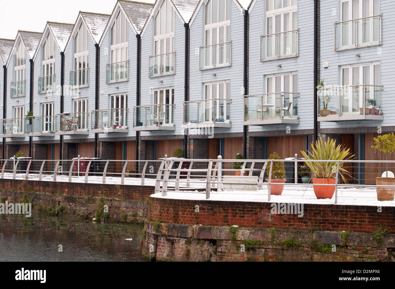 waterside properties with snow laid on the ground and balconies Stock