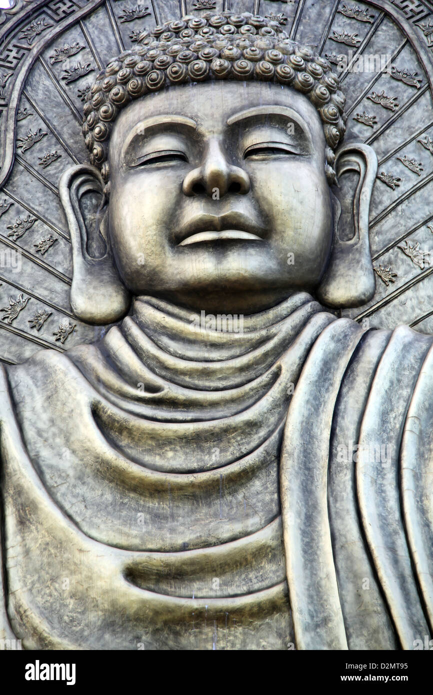 It's a photo of a statue of Buddha made of steel or copper in a Street