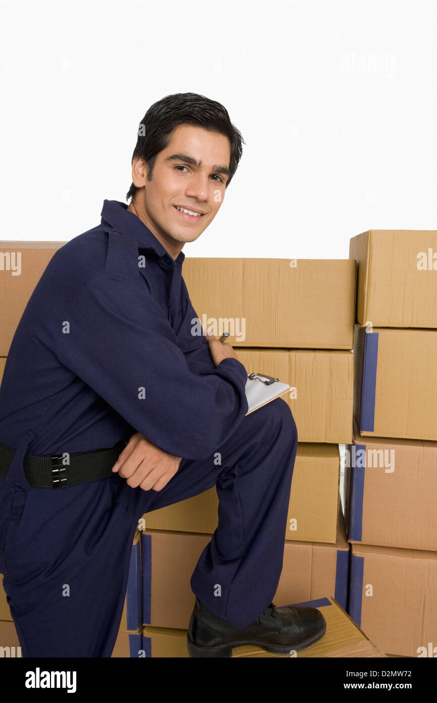 Portrait of a store incharge standing near cardboard boxes and smiling ...