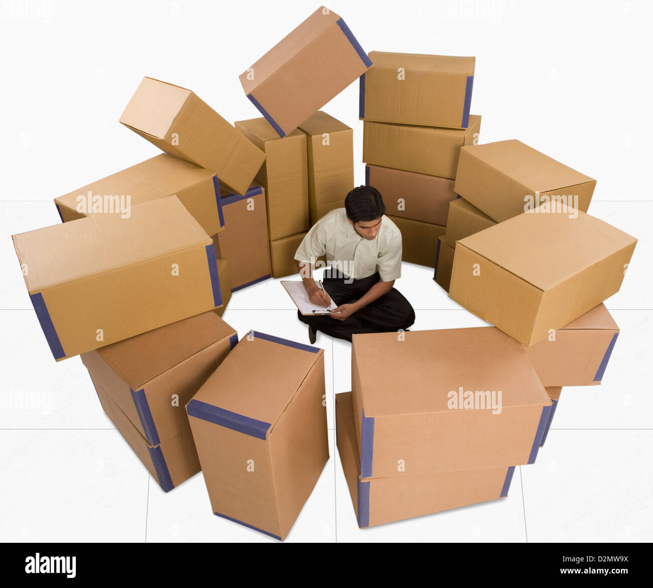 Store incharge sitting with cardboard boxes checking inventory Stock ...