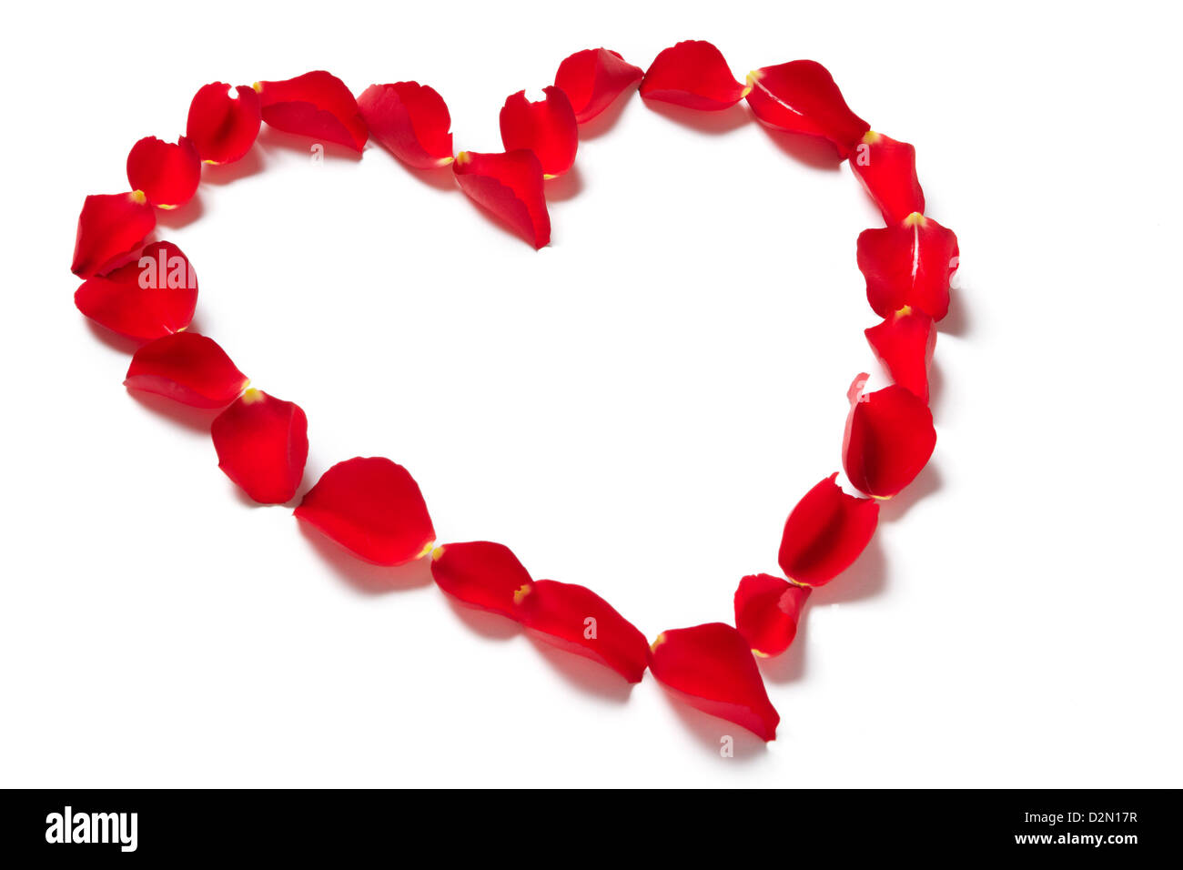 Red rose petals in heart shape on white background Stock Photo - Alamy