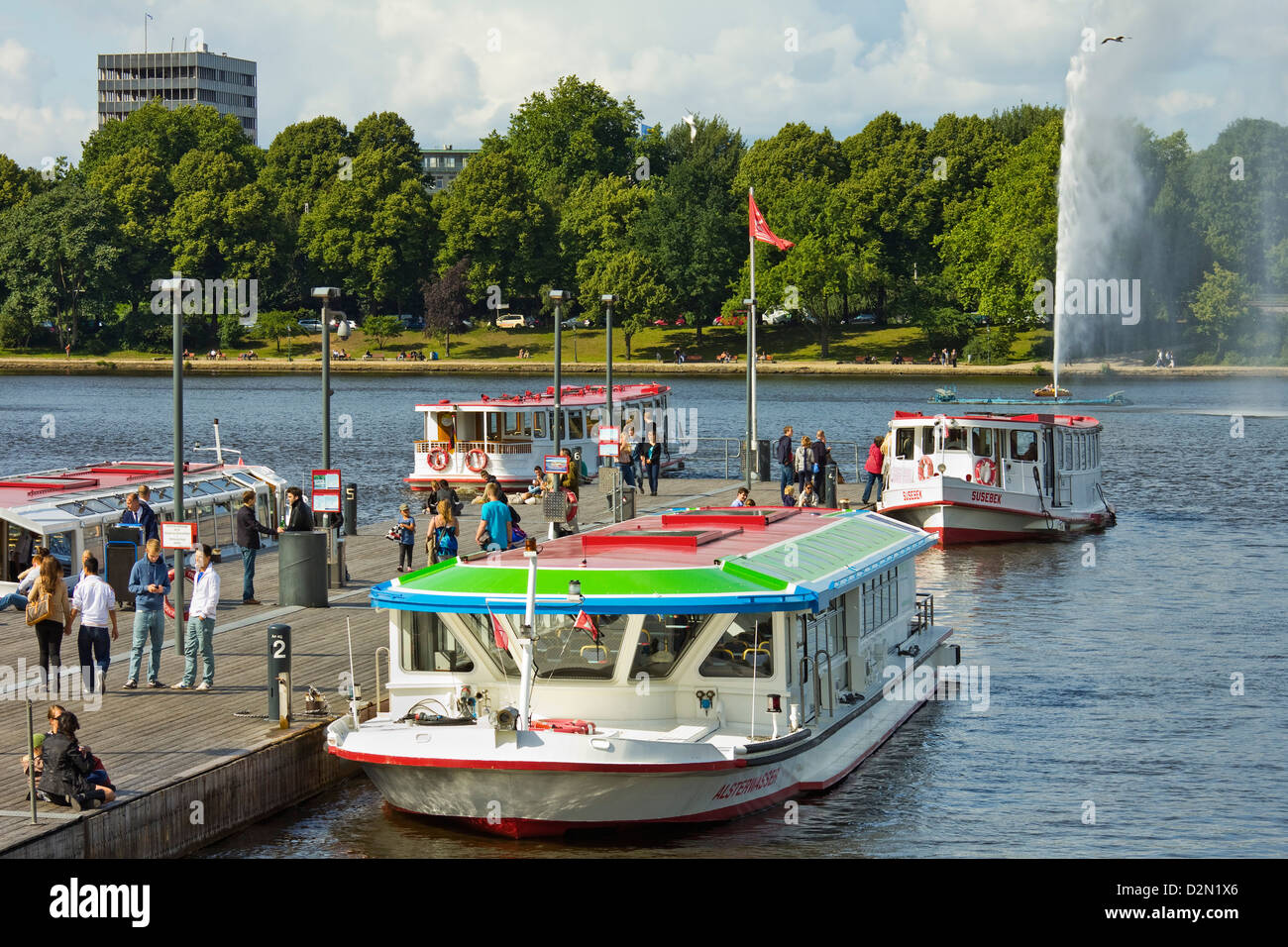 Tour boats that ply Alster Lake moored at the Jungfernstieg with the Lombardsbruecke beyond, Hamburg, Germany, Europe Stock Photo