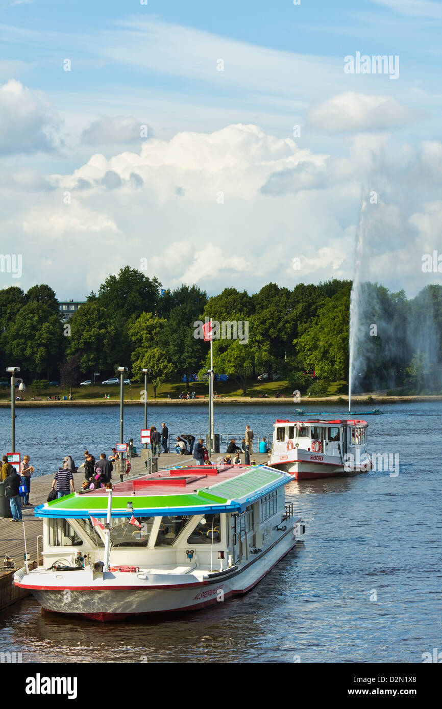Tour boats that ply Alster Lake moored at the Jungfernstieg with the Lombardsbruecke beyond, Hamburg, Germany, Europe Stock Photo