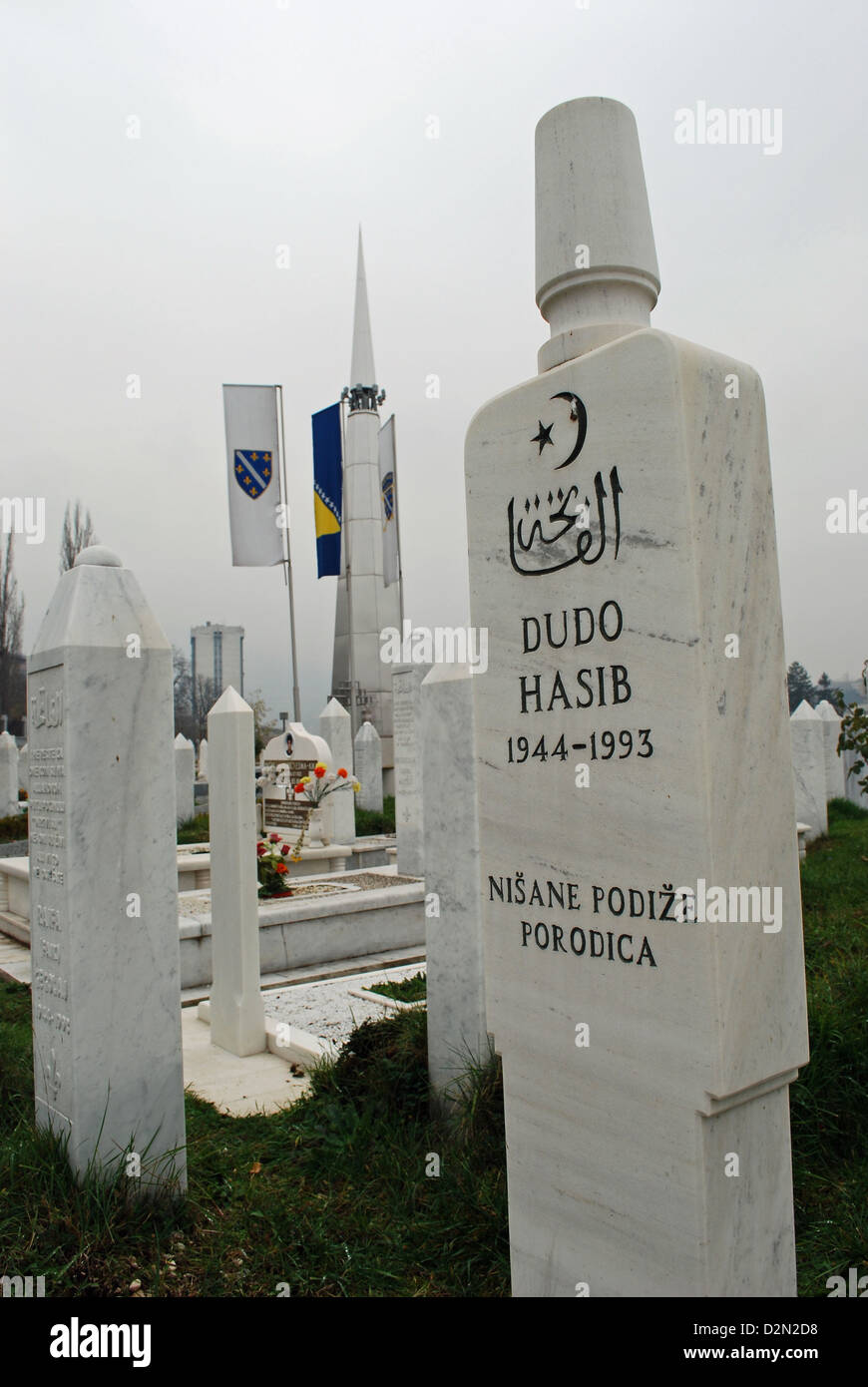 Muslim war graves in Koševo cemetery, Sarajevo. Shahid Martyrs' memorial in the background. Stock Photo