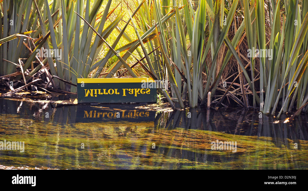 Mirror lakes sign with reflections in the water - Mirror lakes near Milford Sound, South Island, New Zealand Stock Photo