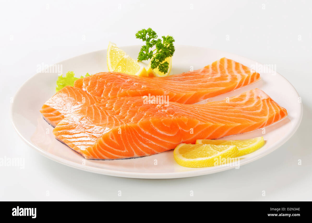Raw salmon fillets and lemon on plate Stock Photo - Alamy