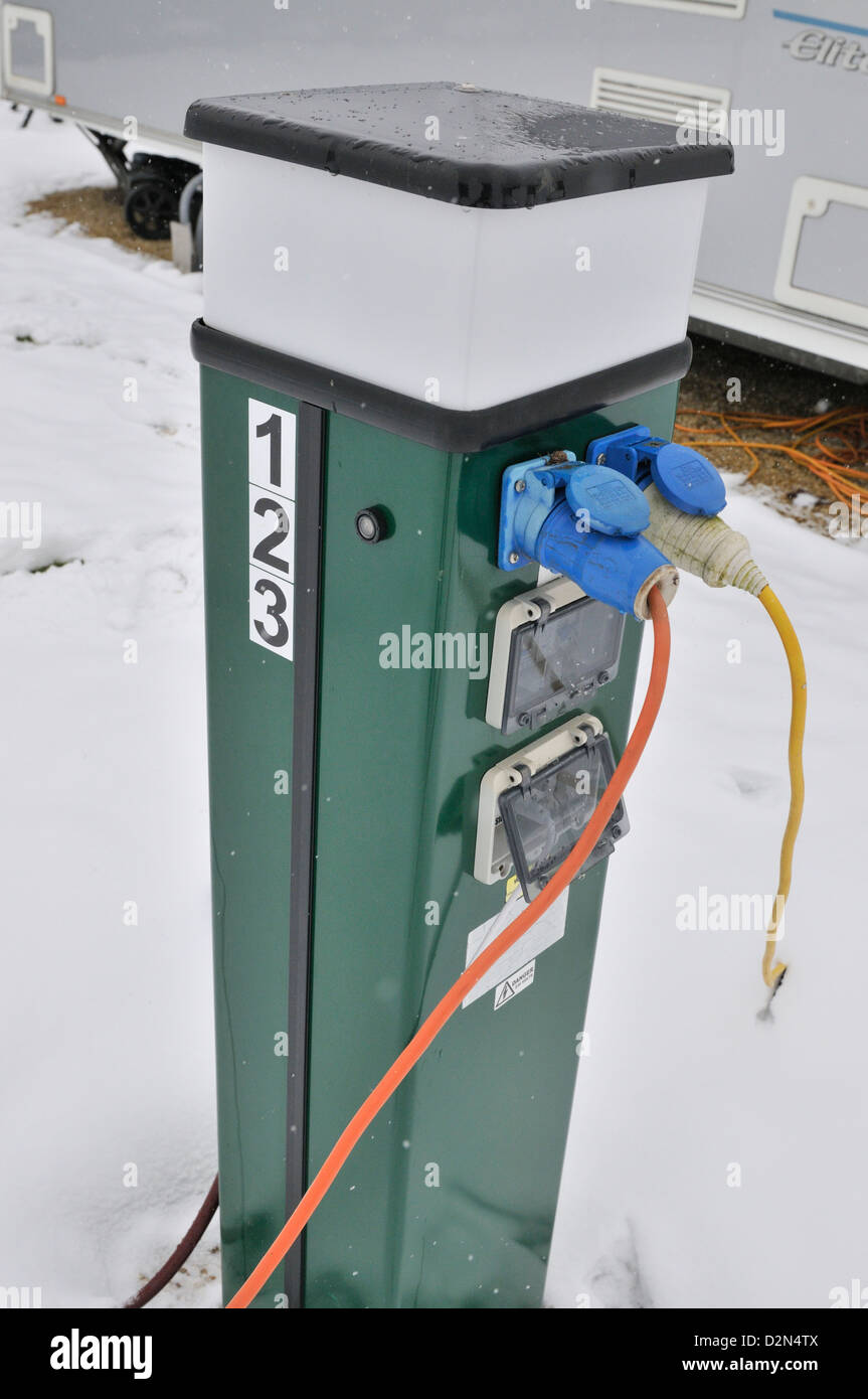 Electric console for supplying 240 volt supply to caravans in an all season caravan park photographed during january's snow fall Stock Photo